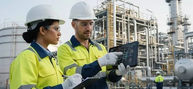 Two engineers reviewing a tablet at an industrial site